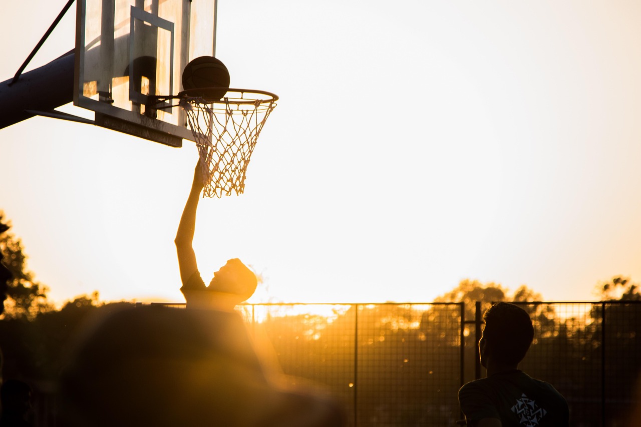 Empty basketball court under arena lights — totals markets are a forecast of combined scoring built from pace and efficiency
